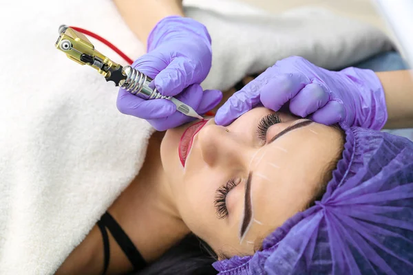 Cosmetologue faisant maquillage permanent sur le visage de la femme — Photo