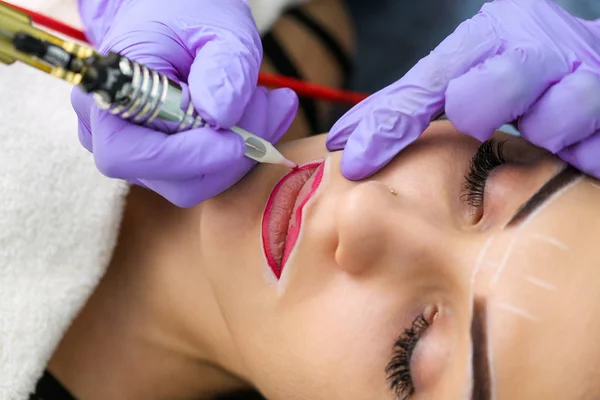 Kosmetolog göra permanent makeup på kvinnans ansikte — Stockfoto