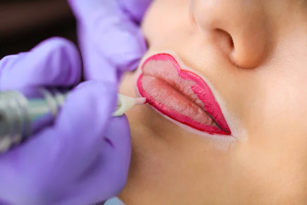 Cosmetologist making permanent makeup on woman's face — Stock Photo, Image