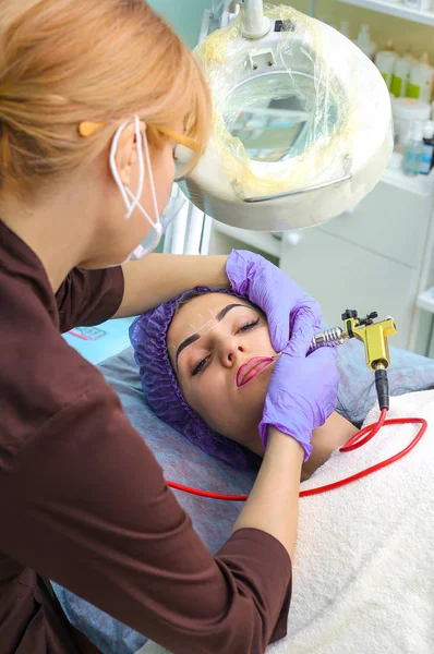 Cosmetologo rendendo permanente il trucco sul viso della donna — Foto Stock