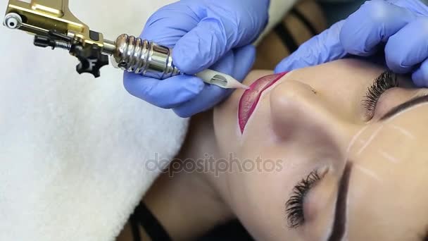 Cosmetologist making permanent makeup on woman's face — Stock Video