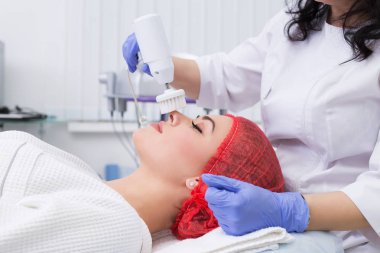 Donanım kozmetolojisi. Deriyi fırçayla temizliyor..