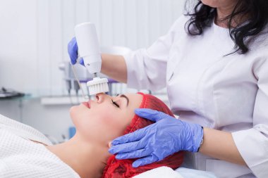 Donanım kozmetolojisi. Deriyi fırçayla temizliyor..