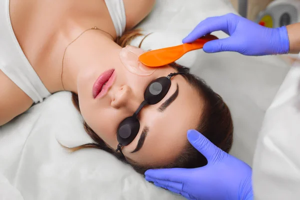 Applying cosmetic gel on the face patient. — Stock Photo, Image