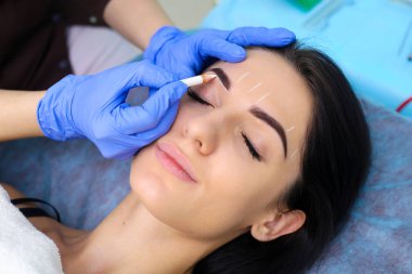 Genç güzel kadın kozmetik salonda kalıcı makyaj yapma.