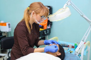 Genç güzel kadın kozmetik salonda kalıcı makyaj yapma.