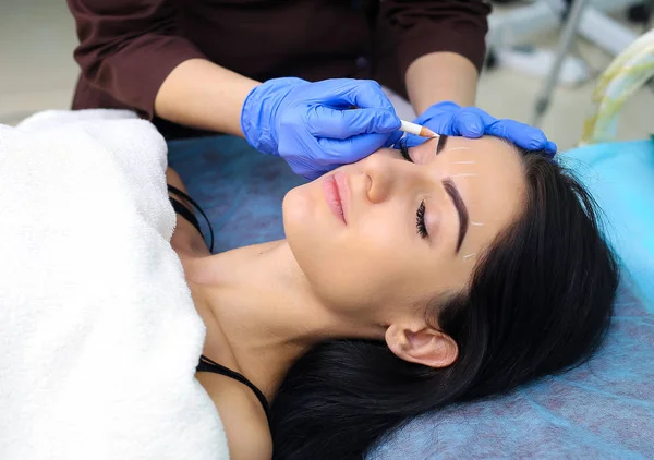 Jovem bela mulher fazendo maquiagem permanente no salão de cosmetologia . — Fotografia de Stock