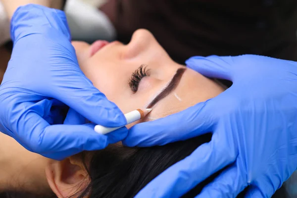 Jovem bela mulher fazendo maquiagem permanente no salão de cosmetologia . — Fotografia de Stock