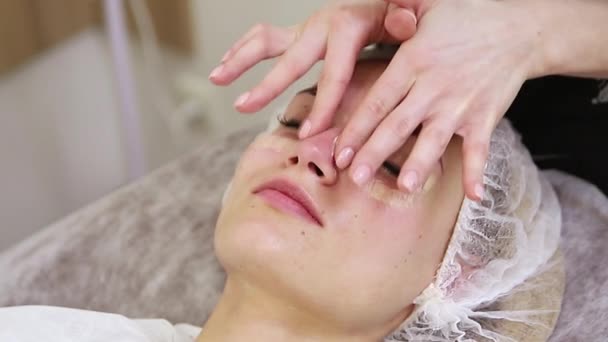 Mladá žena s ošetřením obličeje ve spa salonu — Stock video