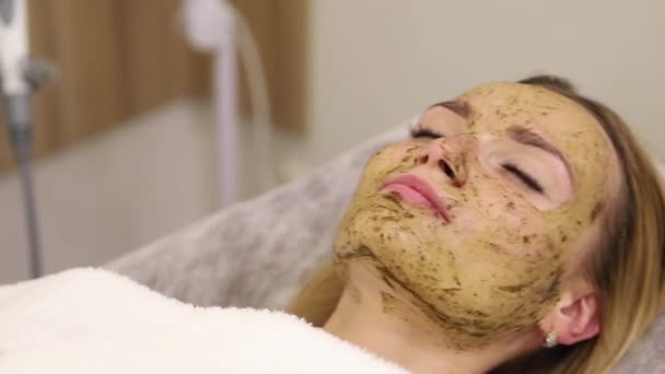 Mladá žena s ošetřením obličeje ve spa salonu — Stock video
