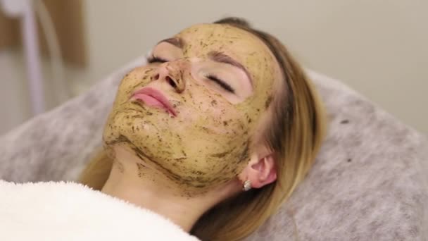 Mujer joven que tiene tratamiento facial en el salón de spa — Vídeo de stock