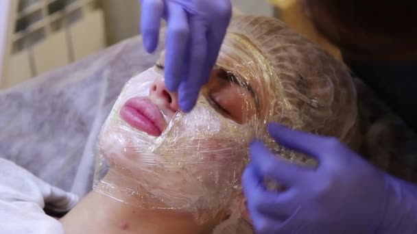 The beautician prepares face girls cream anesthetic before beauty — Stock Video