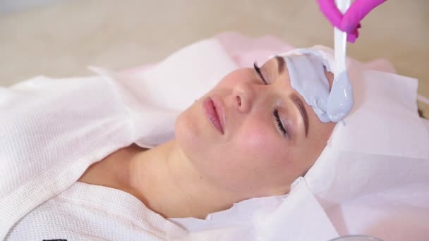 Belle femme avec masque facial au salon de beauté — Video