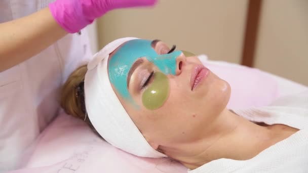 Spa vrouw gezicht reinigende masker toe te passen. — Stockvideo