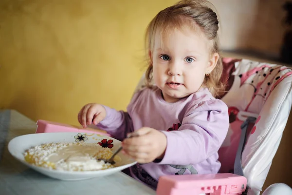Aranyos kislány, eszik a kását — Stock Fotó