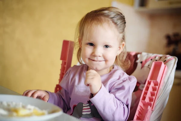 Cute little girl eating porridge — Stock Photo, Image