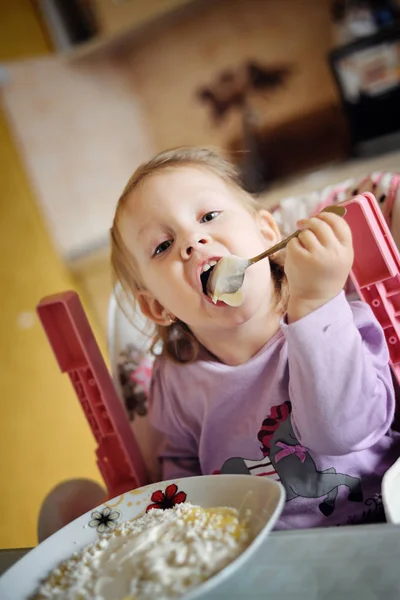 Мила маленька дівчинка їсть кашу Ліцензійні Стокові Фото