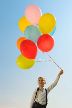 Dışarıda balonları olan mutlu çocuk.