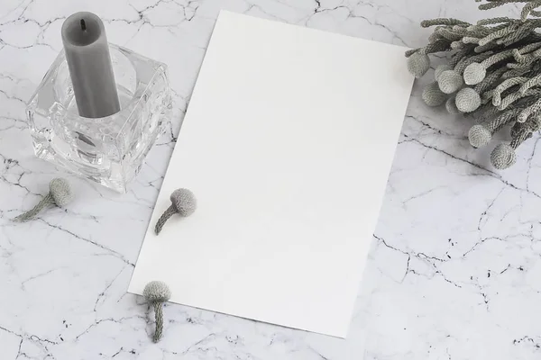 Hoja de papel en blanco sobre mármol con flores de brunia y vela — Foto de Stock