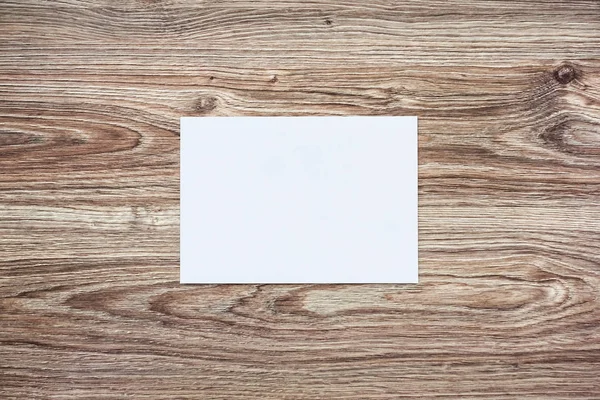 Blanco witte envelop op houten ondergrond — Stockfoto