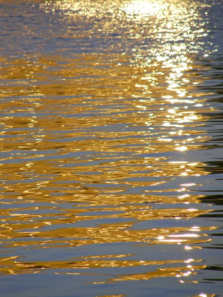 Reflexão dos raios do sol sobre a água . — Fotografia de Stock