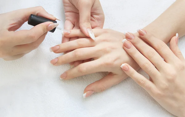 Manikyr göra - kvinnliga händer, som täcker transparent emalj — Stockfoto