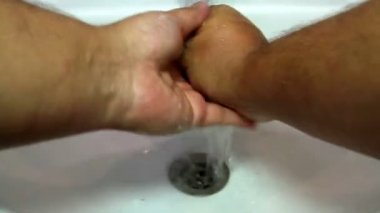 Suyun altında sabunla ellerini yıkamak.