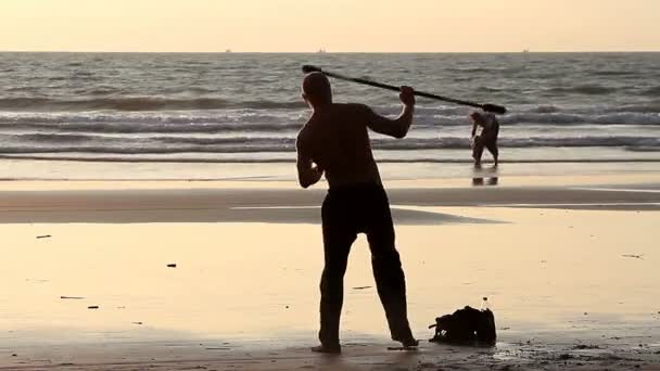 Oidentifierad man spinning pole på stranden. — Stockvideo