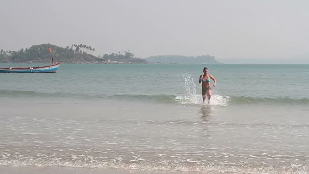 Молодая женщина плавает на пляже — стоковое видео