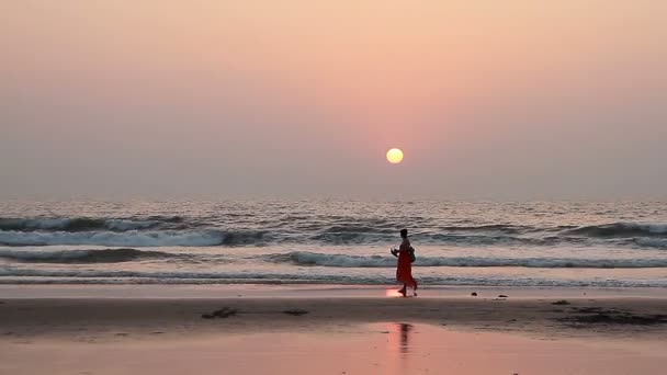 Nő pihentető naplemente sugarak Goa tengerpartján — Stock videók