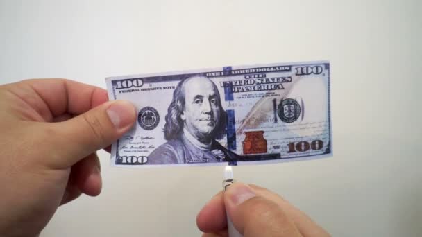 Рука тримає палаючу стодоларову банкноту — стокове відео