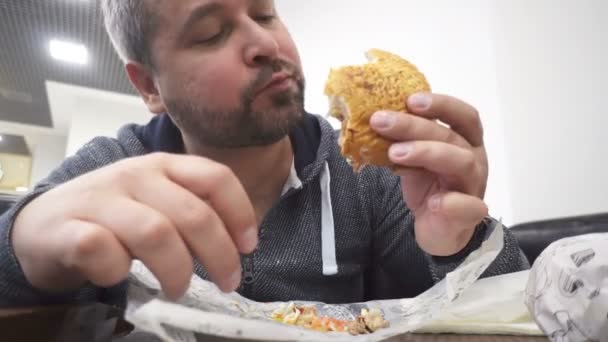 Συσχετισμός Άνθρωπος Τρώει Μεγάλο Χάμπουργκερ Γρήγορο Φαγητό Καφέ — Αρχείο Βίντεο