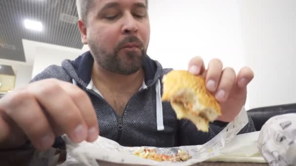 Homem Com Raiva Comendo Hambúrguer Grande Fast Food Café — Vídeo de Stock