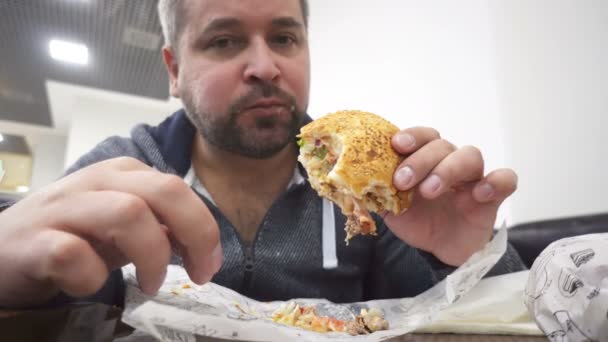 Homem Com Raiva Comendo Hambúrguer Grande Fast Food Café — Vídeo de Stock