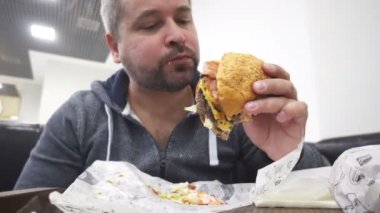Aç adam yeme büyük hamburger fast food Cafe