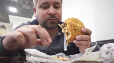 Aç adam yeme büyük hamburger fast food Cafe