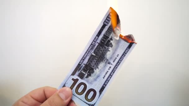 Mano sosteniendo un billete de cien dólares en llamas — Vídeos de Stock