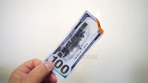 Mano sosteniendo un billete de cien dólares en llamas — Vídeos de Stock