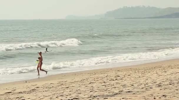Mooi meisje Frisbee spelen op het strand — Stockvideo