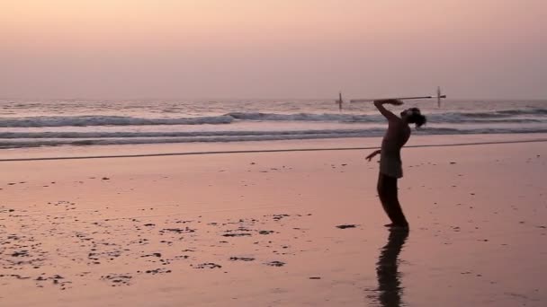 Onbekende man spinnen paal op het strand. — Stockvideo