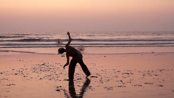 Oidentifierad man spinning pole på stranden. — Stockvideo