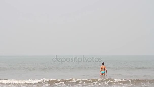 Gelukkig jonge vrouw zwemmen aan het strand — Stockvideo