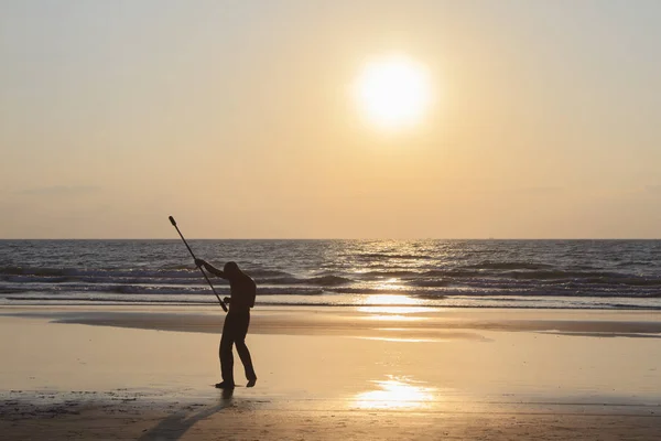 Unbekannter dreht Stange am Strand. — Stockfoto