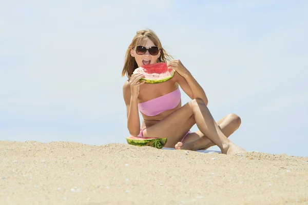 Jovem fêmea comendo melancia na praia — Fotografia de Stock