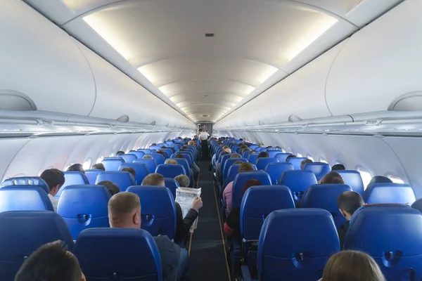 Interior del avión con pasajeros en asientos. — Foto de Stock