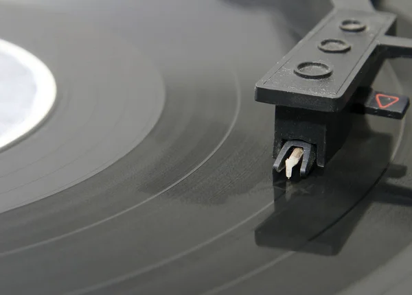 Turntable with stylus running along a vinyl record — стоковое фото