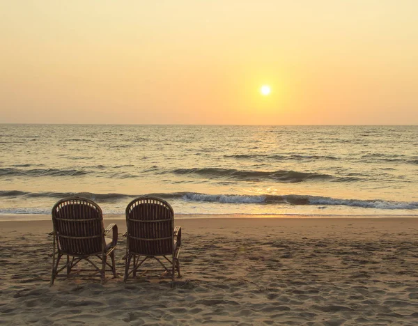 Two chairs near coastline at sunset time — Stock Photo, Image