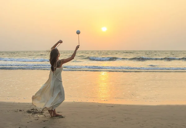 Unbekannte drehen Poi am Strand. — Stockfoto