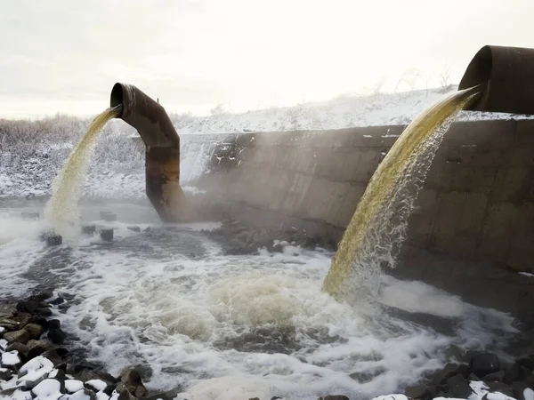 Wastewater from two large rusty pipes merge into the river in cl — Stock Photo, Image