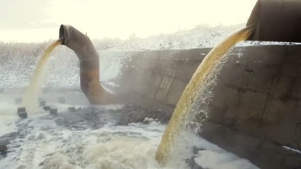 大而生锈的管子排出的废水在蒸汽的云中汇入河里 — 图库视频影像